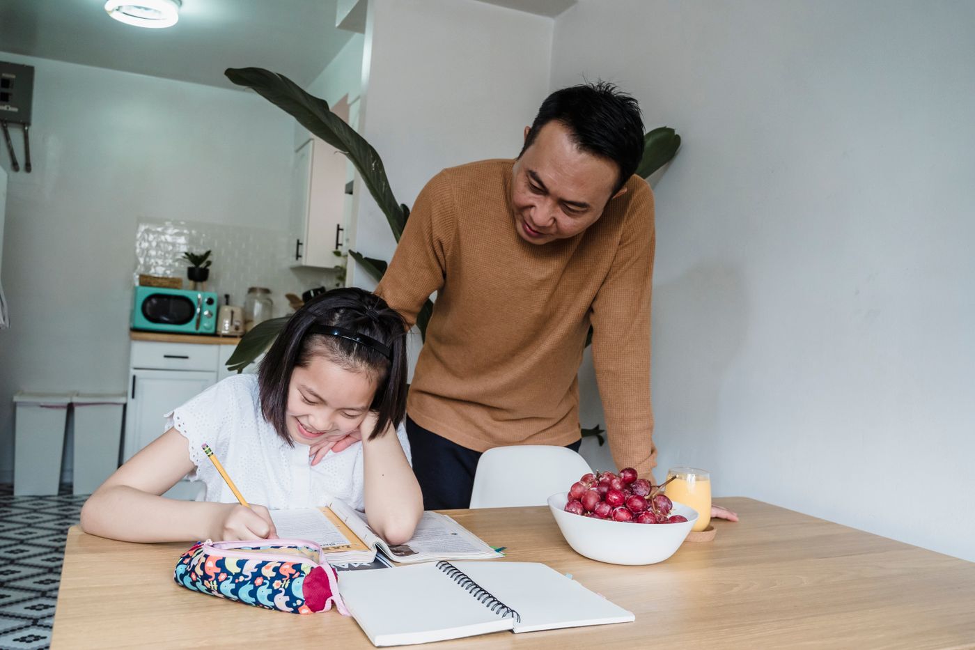 A father and daughter learning together at home