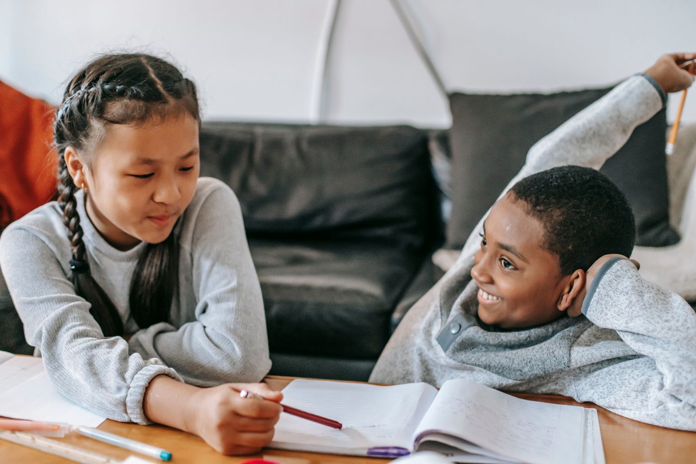 Two children sharing ideas while working on a learning activity